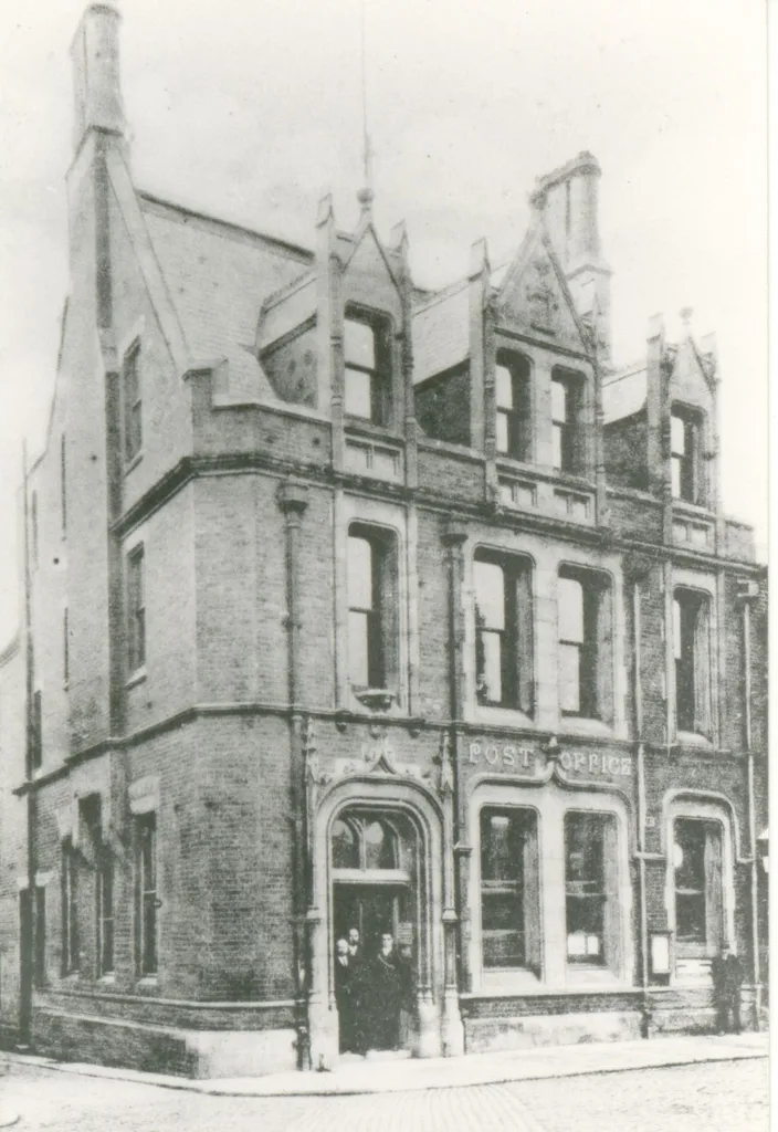 The post office was built in 1887 in 'French, mediaeval domestic style' in red brick with limestone dressings and slate roof.