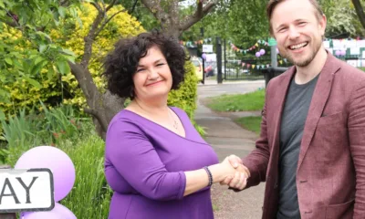 Headteacher Rachel Snape with Cllr Alex Beckett on problematic junction outside the school, posters in the background.