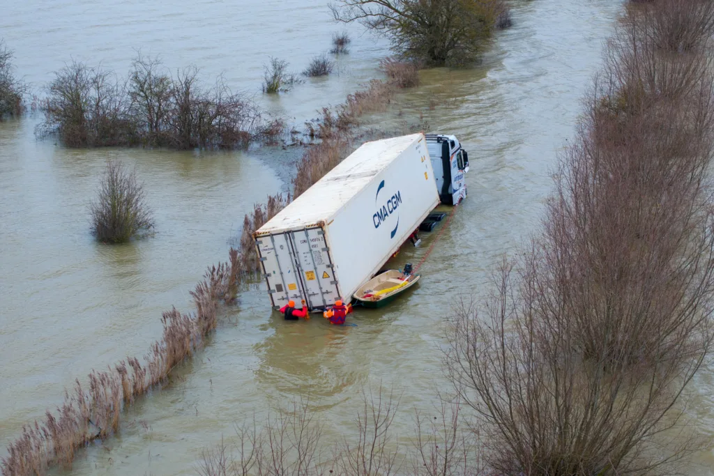 Manchetts staff weighing up the options to rescue lorry and container from flooded A1101 at Welney on the Cambridgeshire/Norfolk border. PHOTO: Terry Harris
