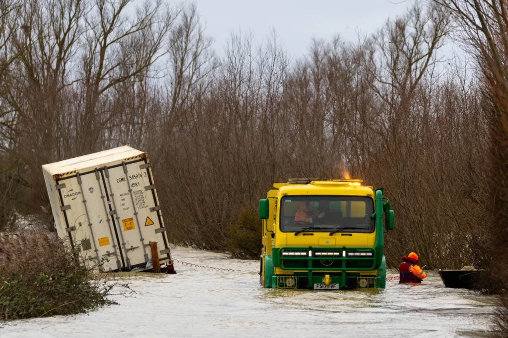 Manchetts staff weighing up the options to rescue lorry and container from flooded A1101 at Welney on the Cambridgeshire/Norfolk border. PHOTO: Terry Harris
