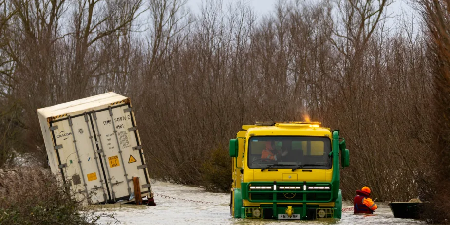 Manchetts staff weighing up the options to rescue lorry and container from flooded A1101 at Welney on the Cambridgeshire/Norfolk border. PHOTO: Terry Harris