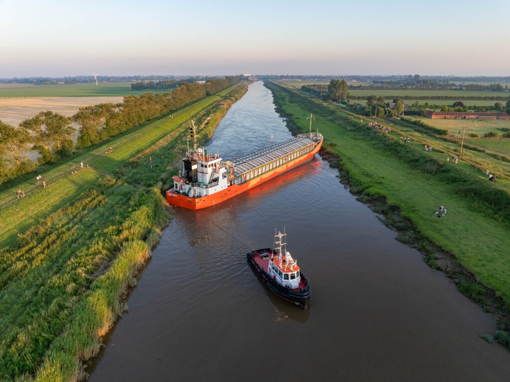 Spectators gathered by the River Nene in Wisbech as the Baltic Arrow, with its cargo of timber from Latvia, was finally freed and pulled into port. PHOTO: Terry Harris 